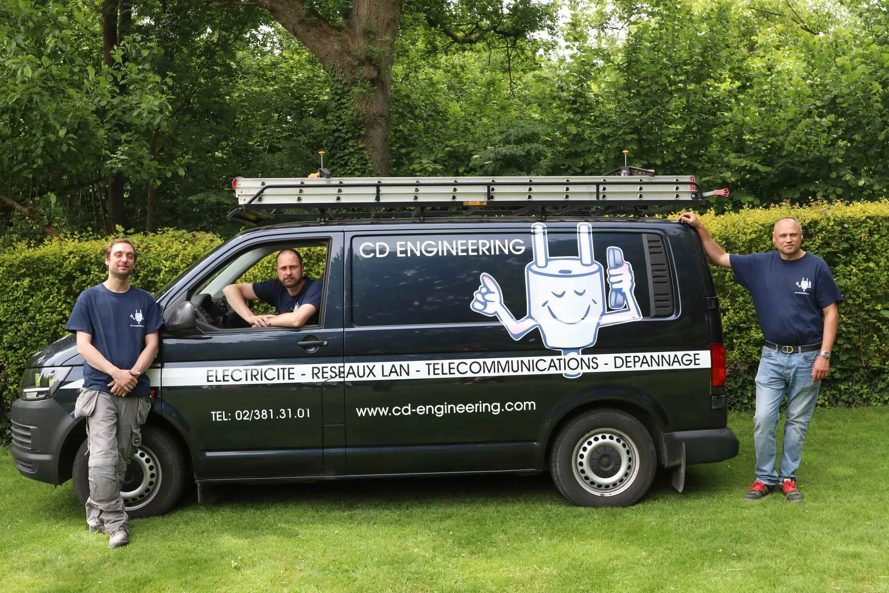 L'équipe CD Engineering, trois électriciens devant la camionnette noire avec la mascotte
